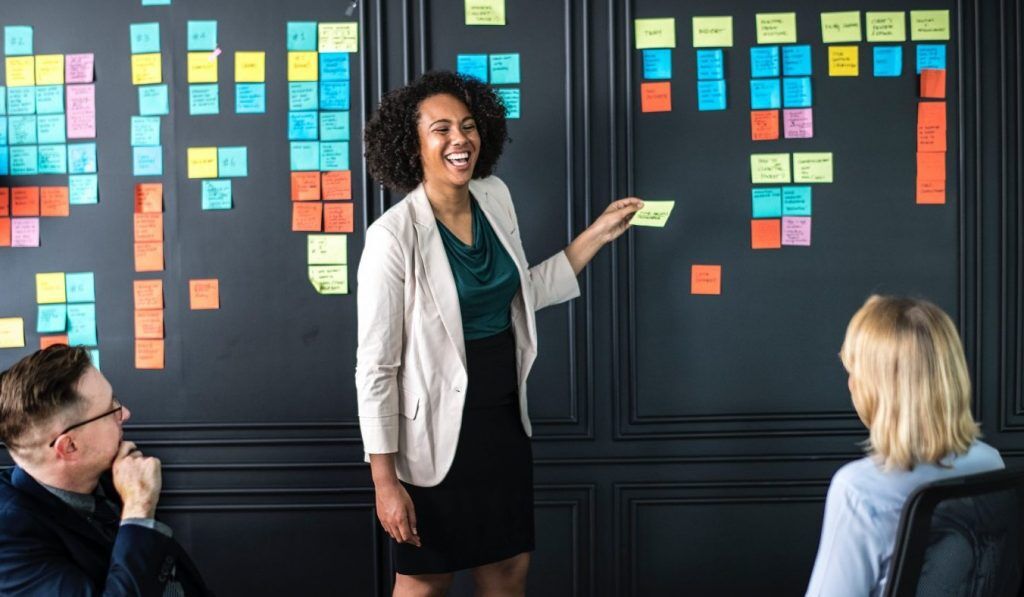 woman holding sticky note in work meeting