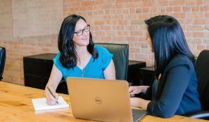 two woman collaborating on a laptop